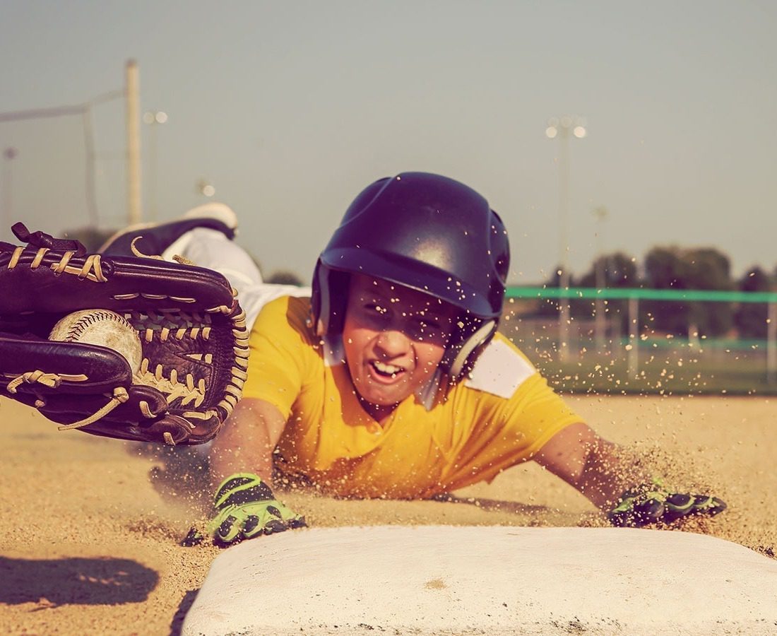 Boy sliding into base head first